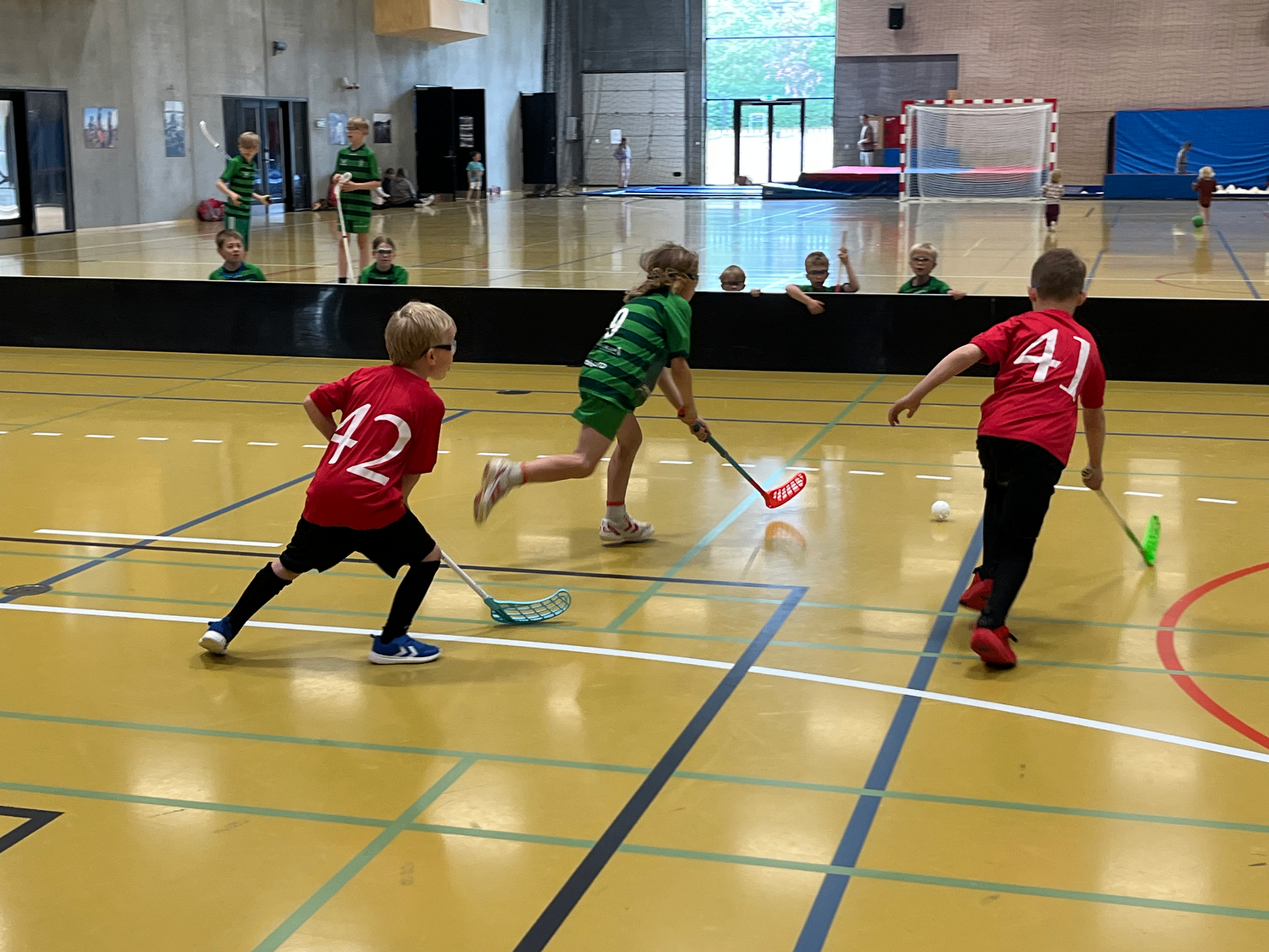 Børn spiller floorball-kamp i hallen hos Lystrup Vikings – rødt hold mod grønt hold under U-stævne
