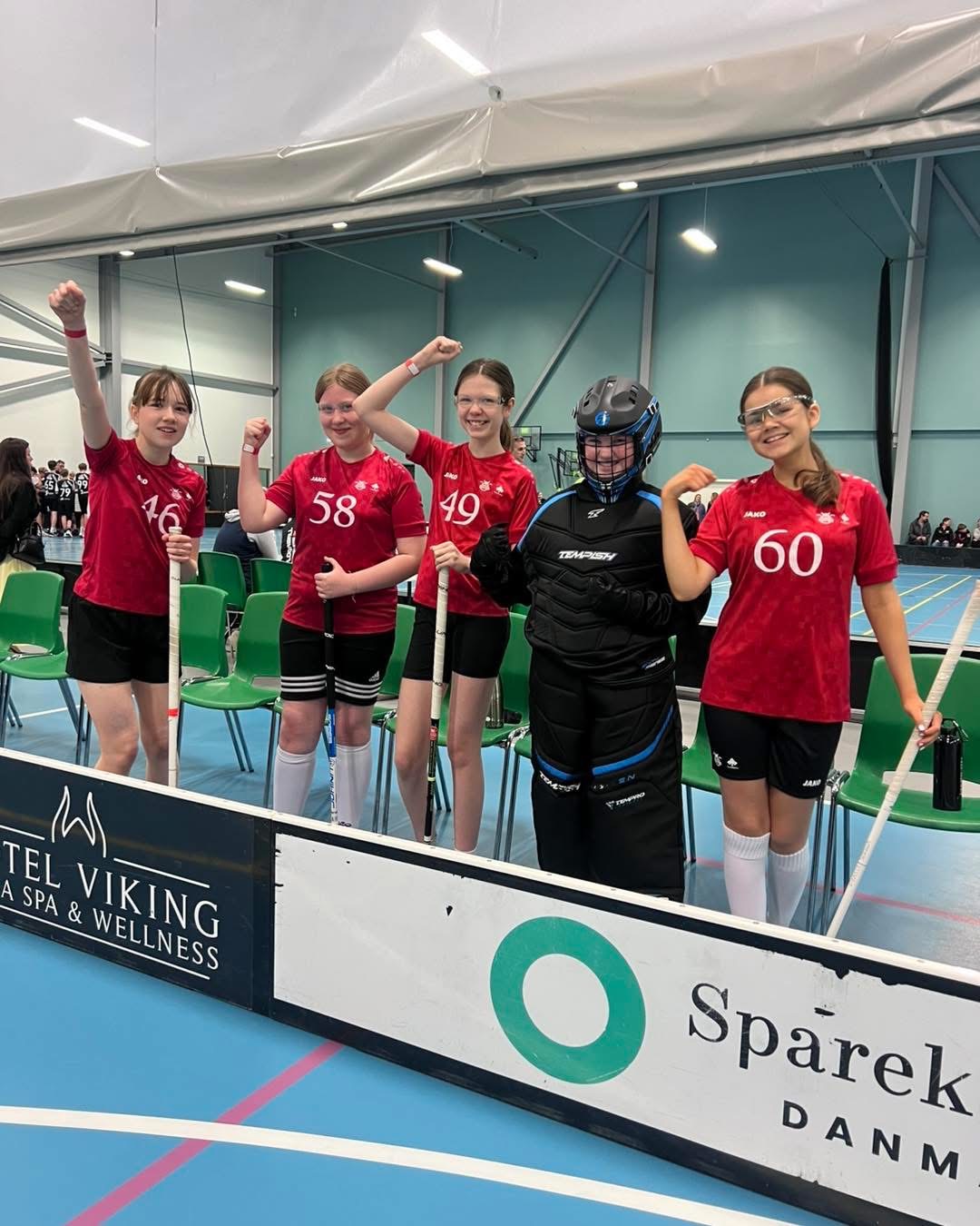 Glade pigespillere fra Lystrup Vikings floorball jubler efter kamp med stave og målmandsudstyr